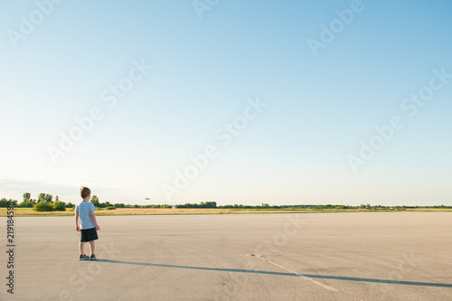 boy watching airplane takeoff