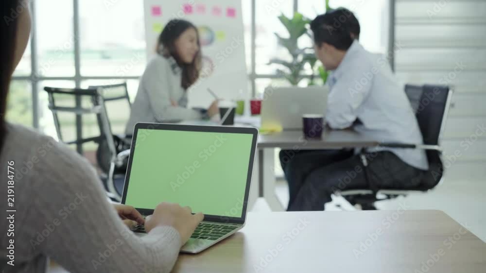 Business Technology Concepts - Digital lifestyle working office. Woman hands typing laptop computer with green screen on table in office. Chroma key.
