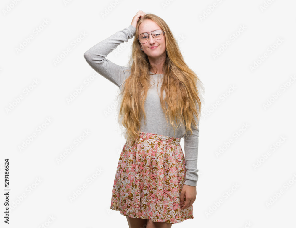 Blonde teenager woman wearing flowers skirt confuse and wonder about question. Uncertain with doubt, thinking with hand on head. Pensive concept. Blonde teenager woman wearing flowers skirt confuse and wonder about question. Uncertain with doubt, thinking with hand on head. Pensive concept.