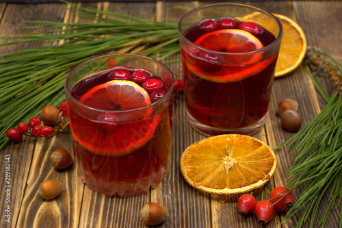Hot winter or autumn cranberry drink on wooden background