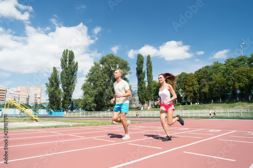 Young family promoting healthy lifestyle. Woman and man run stadium. Couple runners training outdoors. Couple or family live healthy lifestyle. Coach and sportsman motion run training before race