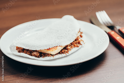 Brazilian Tapioca with cheese (coalho) over a wooden table photo