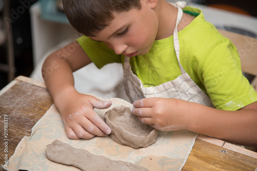 Pottery workshop for kids, raw clay, sculpting tools, glazing and painting clay pots