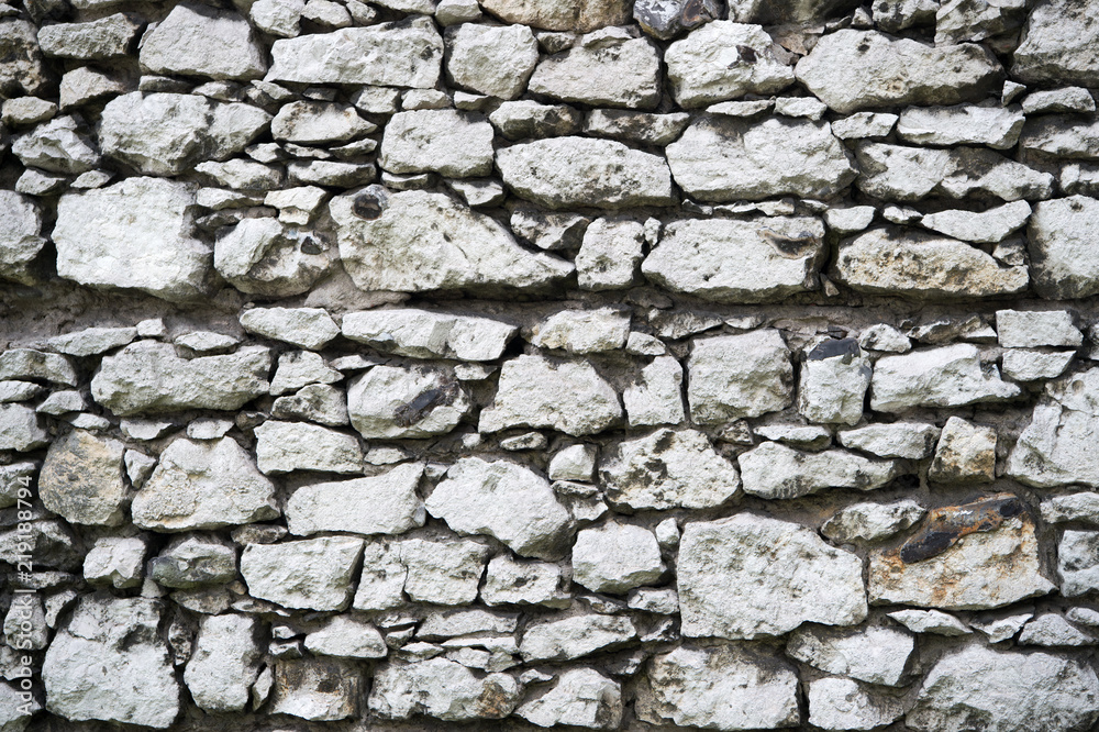 Old stony wall in Krakow texture background. Ancient background empty wall made out of stones in Krakow. Old building material concept. Ancient stony fortification or part of defenses Old stony wall in Krakow texture background. Ancient background empty wall made out of stones in Krakow. Old building material concept. Ancient stony fortification or part of defenses