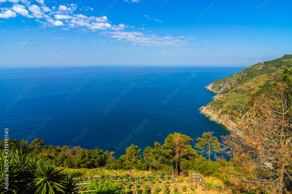 View over the blue Mediterranean Sea and the mountains of Cinque Terre, Italy on a sunny day with blue sky. View over the blue Mediterranean Sea and the mountains of Cinque Terre, Italy on a sunny day with blue sky.