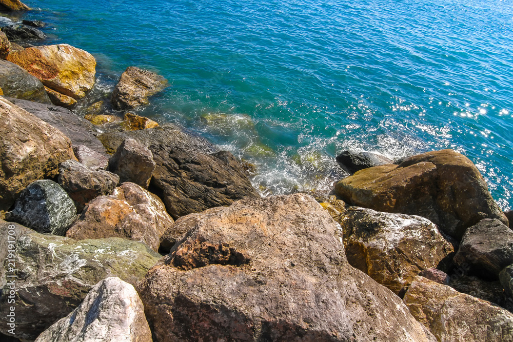 Rocks in the blue Mediterranean Sea on a bright sunny day.