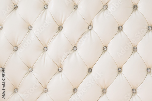 Beige soft tapestry pattern background with symmetrical buttons on the corners of diamonds. Soft and expensive furniture elements. Luxury background