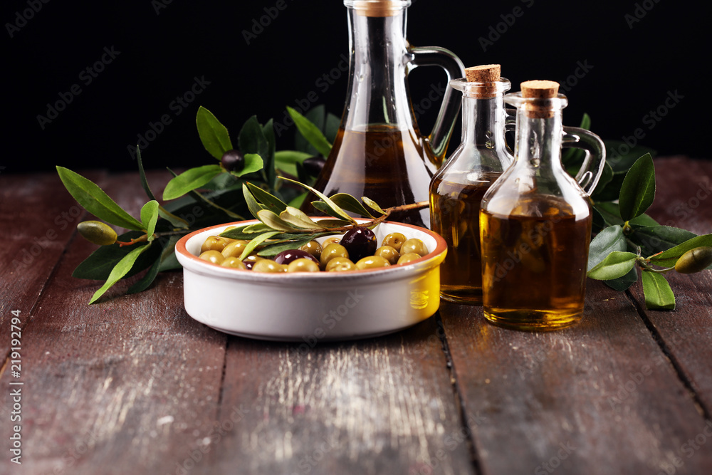 Olives. Bottle virgin olive oil and oil in a bowl with some olives Olives. Bottle virgin olive oil and oil in a bowl with some olives