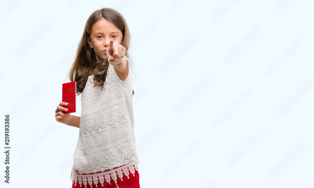Brunette hispanic girl holding passport of Switzerland pointing with finger to the camera and to you, hand sign, positive and confident gesture from the front Brunette hispanic girl holding passport of Switzerland pointing with finger to the camera and to you, hand sign, positive and confident gesture from the front