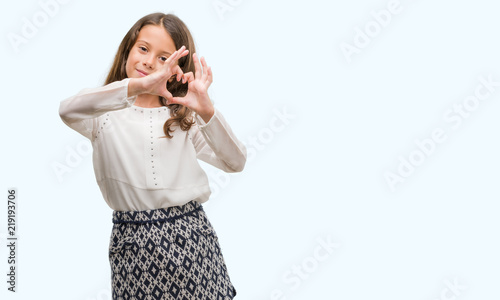 Brunette hispanic girl smiling in love showing heart symbol and shape with hands. Romantic concept.