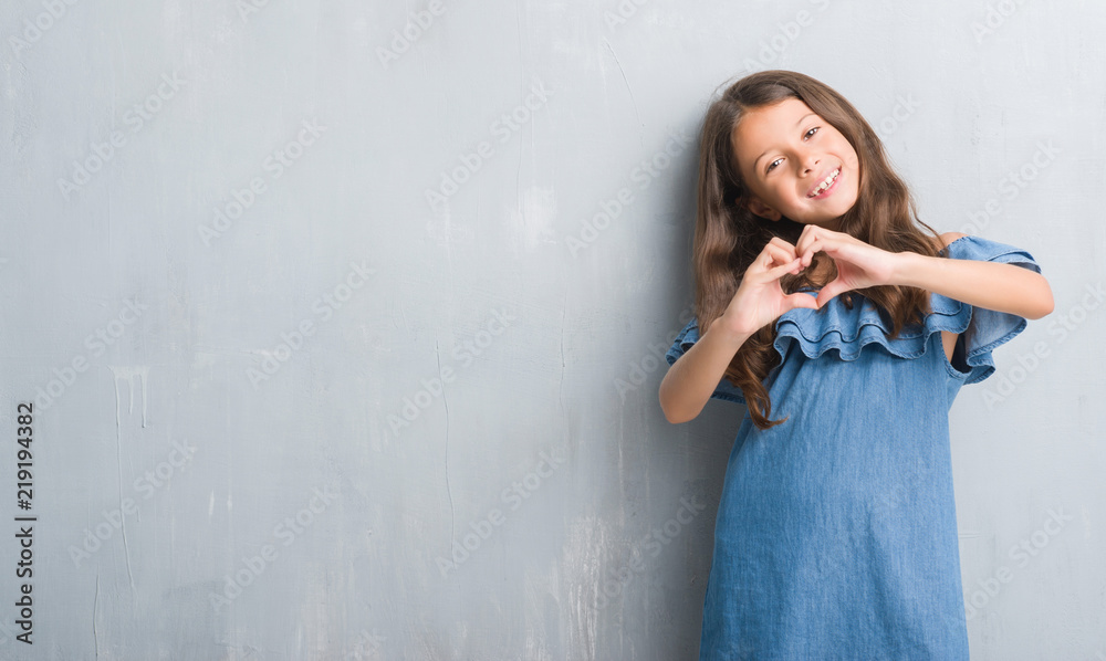 Obraz premium Young hispanic kid over grunge grey wall relax and smiling with eyes closed doing meditation gesture with fingers. Yoga concept.