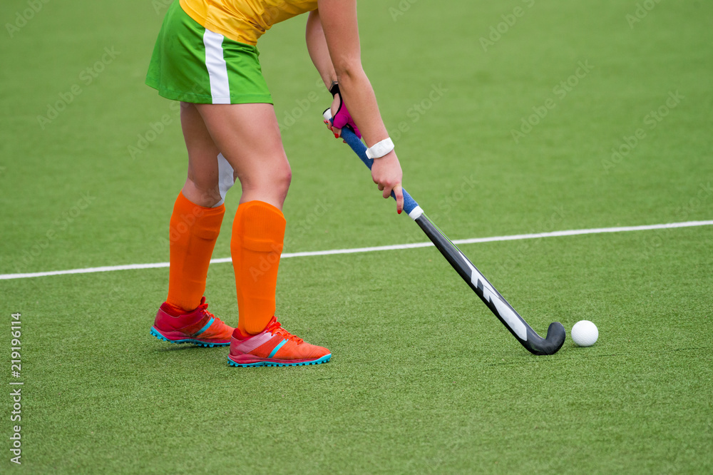 Obraz premium Young hockey player woman with ball in attack playing field hockey game