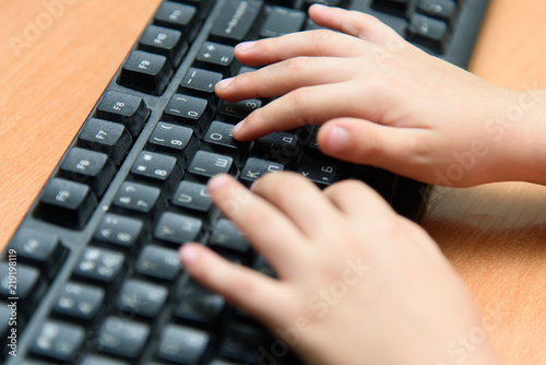 Online education of school children. Children hands on keyboard pc close up.