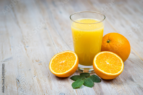 Orange juice and citrus fruits on rustic wooden table with copy space