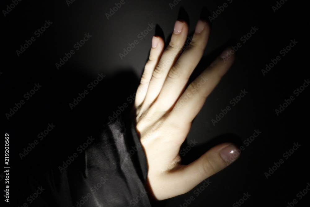 Fototapeta premium Hand against black wall