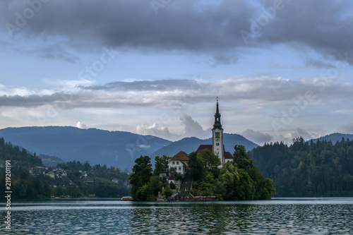 Church situated on an island on Bled lake and mountains in background.  Slovenia  Europe. European travel.