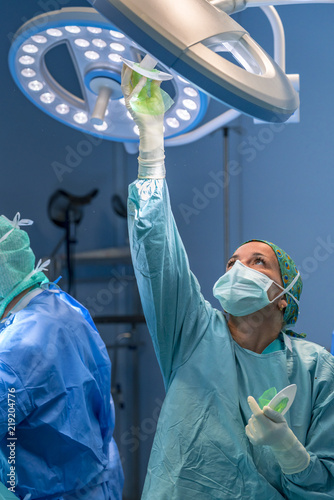 Surgical assistant placing the operating room lamp