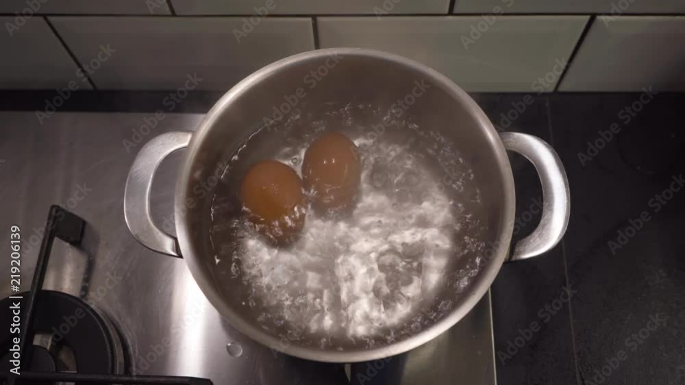 Closeup of two brown eggs boiling in hot water