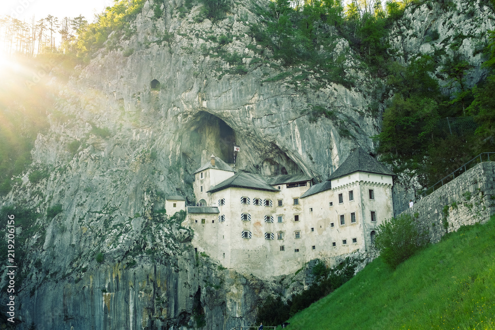 Predjama castle in the rock wall with sunrays on the left side, Slovenia