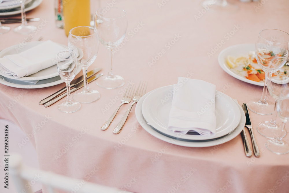 stylish pink table with wine glasses, cutlery, napkin and delicious food and drinks. luxury catering in restaurant. modern wedding reception. pink and white wedding settings stylish pink table with wine glasses, cutlery, napkin and delicious food and drinks. luxury catering in restaurant. modern wedding reception. pink and white wedding settings