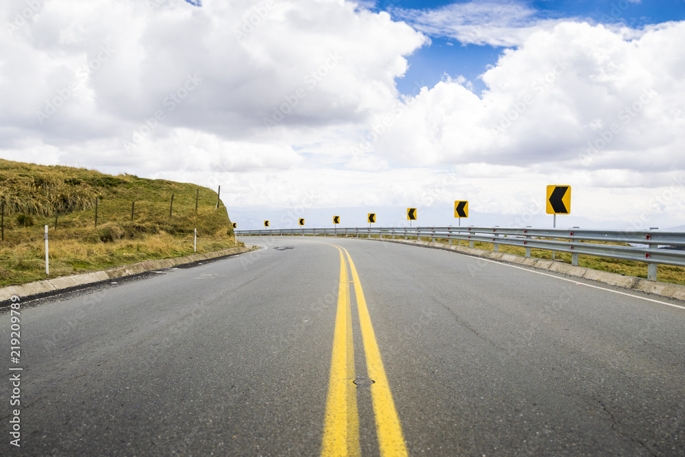 Naklejka premium Part of a highway road in the middle of the Andean mountain region of Ecuador. It's a clear blue sky day with some clouds.