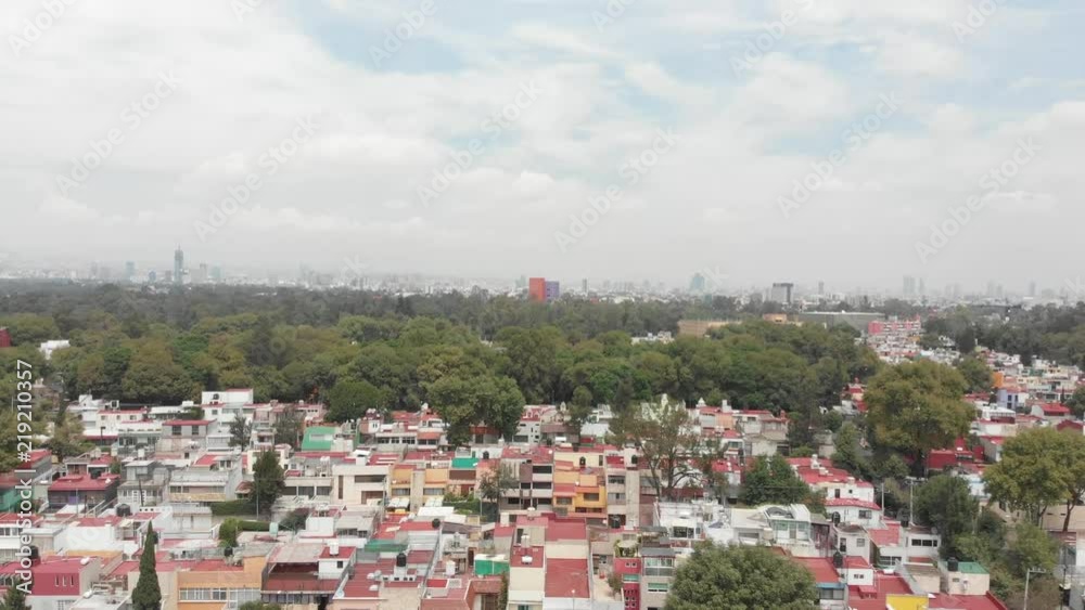 Aerial panoramic view of Coyoacan in Mexico City with drone flying up on a clear day and views of the skyline.