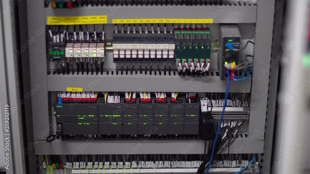 Wiring and electrical cabinet in industrial machine. Electronics closet packed with wires. Lights blinking to indicate status of connection and status in communications and electric supply rack. Wiring and electrical cabinet in industrial machine. Electronics closet packed with wires. Lights blinking to indicate status of connection and status in communications and electric supply rack.