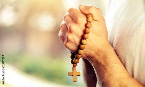 Hands of human praying on cross bokeh background