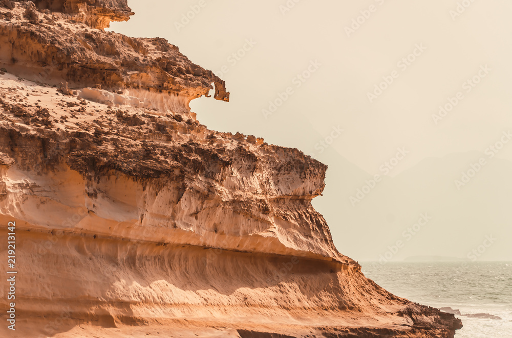 nature poster. yellow sand rock and blue ocean