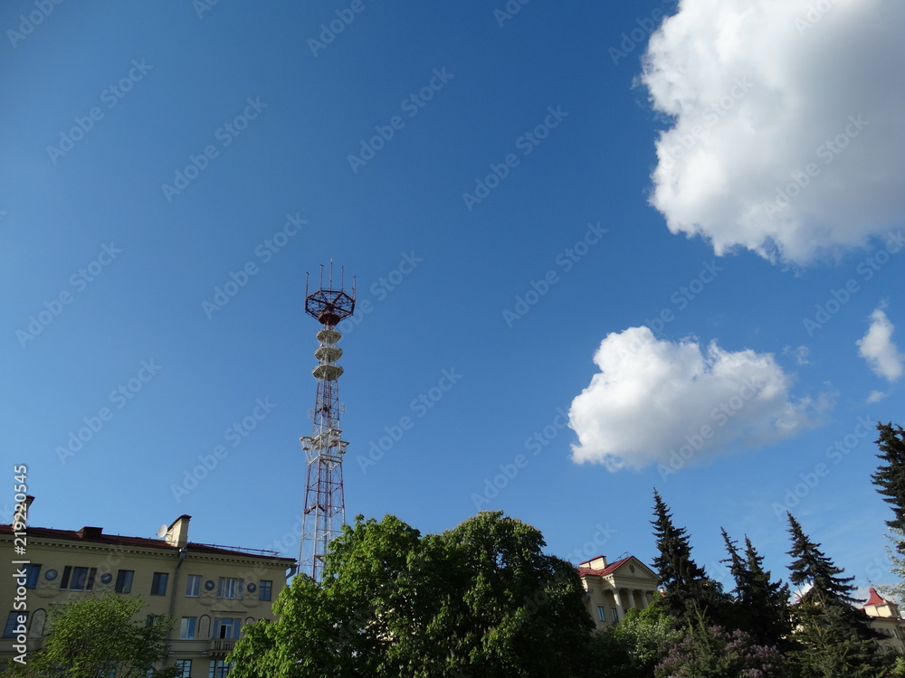 Obraz premium Minsk, tower, telecommunications, journalism, television, broadcasting, satellite, antenna, ONT, TV channels, view from Victory Square, after houses, roofs, bright sky, clouds, trees.