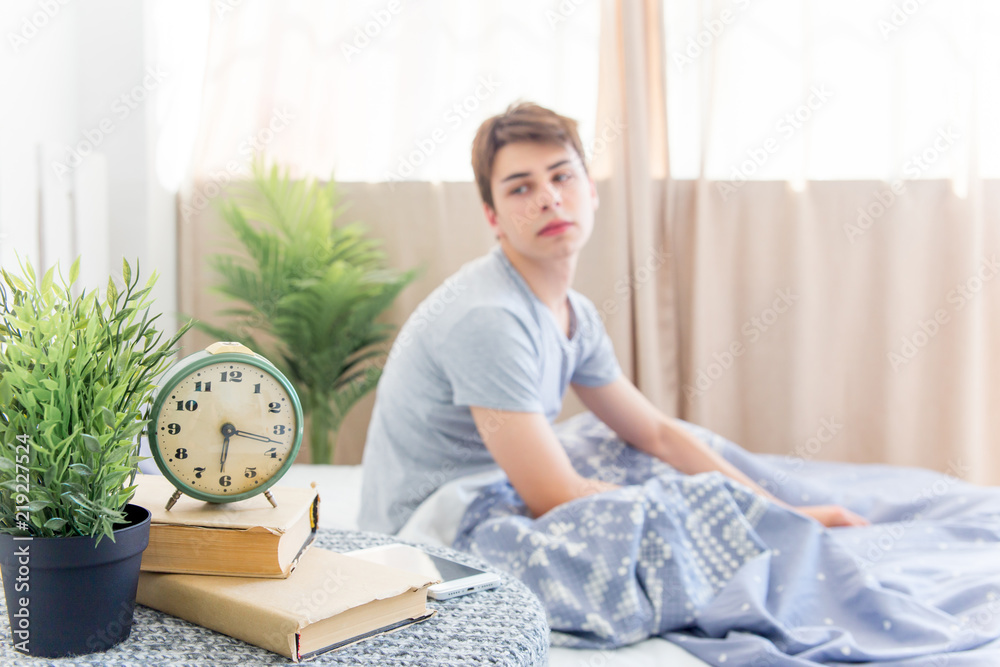 A young man waking up in bed in the morning A young man waking up in bed in the morning