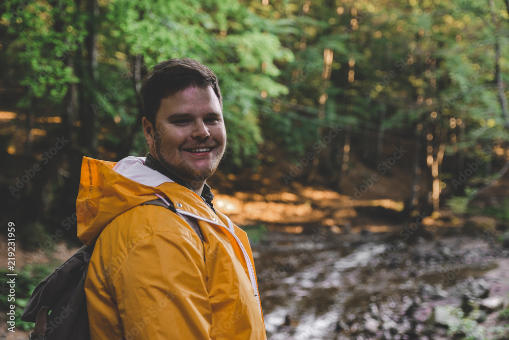 man stand in the middle of forest in yellow raincoat. man stand in the middle of forest in yellow raincoat.