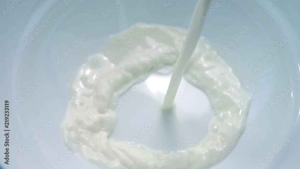 Fresh milk being poured into a white bowl Fresh milk being poured into a white bowl