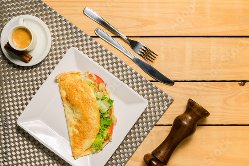 Crepioca - pancake of cassava (tapioca) with tomatoes, letuce and cheese on plate on wooden background pinus - breakfast photo