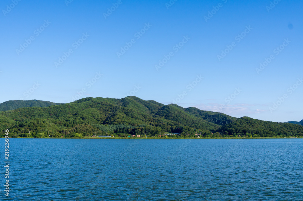 Refreshing riverside green mountain at summer afternoon