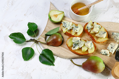 Fresh sweet Pears salad and bruschetta with blue cheese, walnut on wooden board background. Close up. Flat lay. copy text