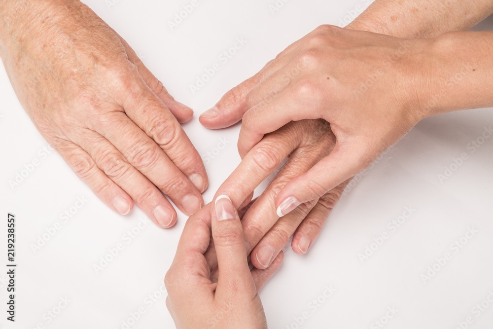 Young Woman's Hands Touching and Holding an Old Woman's Hand Young Woman's Hands Touching and Holding an Old Woman's Hand