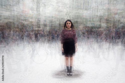 young asian woman standing still amidst a busy crowd of fast moving people                               