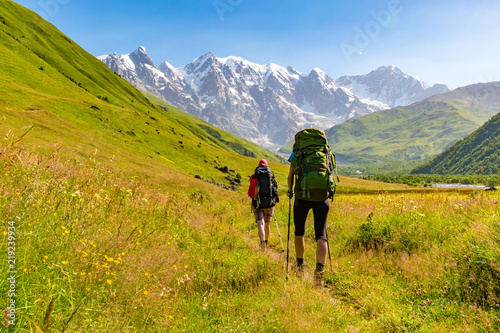 Young active girls hiking in Greater Caucasus mountains, Mestia district, Svaneti, Georgia photo