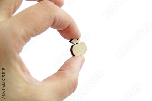 small wooden apple in hand on isolated background