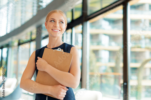 Happy beautiful business woman with clipboard in the office. Free Download Happy beautiful business woman with clipboard in the office. - GFXLoad