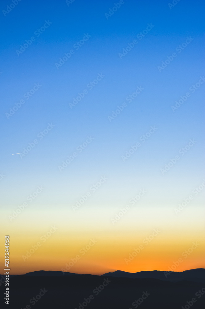 Sunset or sunrise background wallpaper photo of blue, orange and yellow sky over a horizont. Sunset or sunrise background wallpaper photo of blue, orange and yellow sky over a horizont.