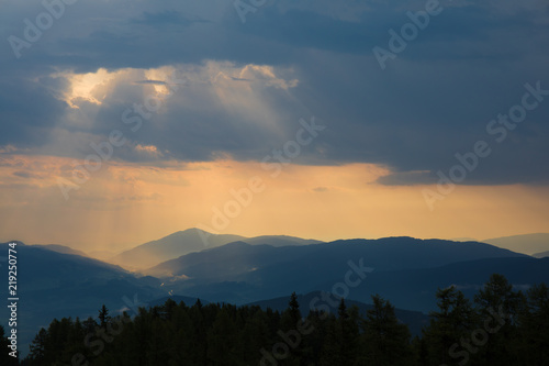 Fototapeta Naklejka Na Ścianę i Meble -  Erste Sonnenstrahlen durch die Wolken bei Sonnenaufgang