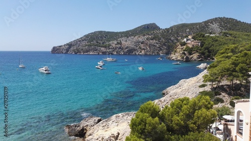 Tranquil mallorquin coastline with small ships and hills in the background