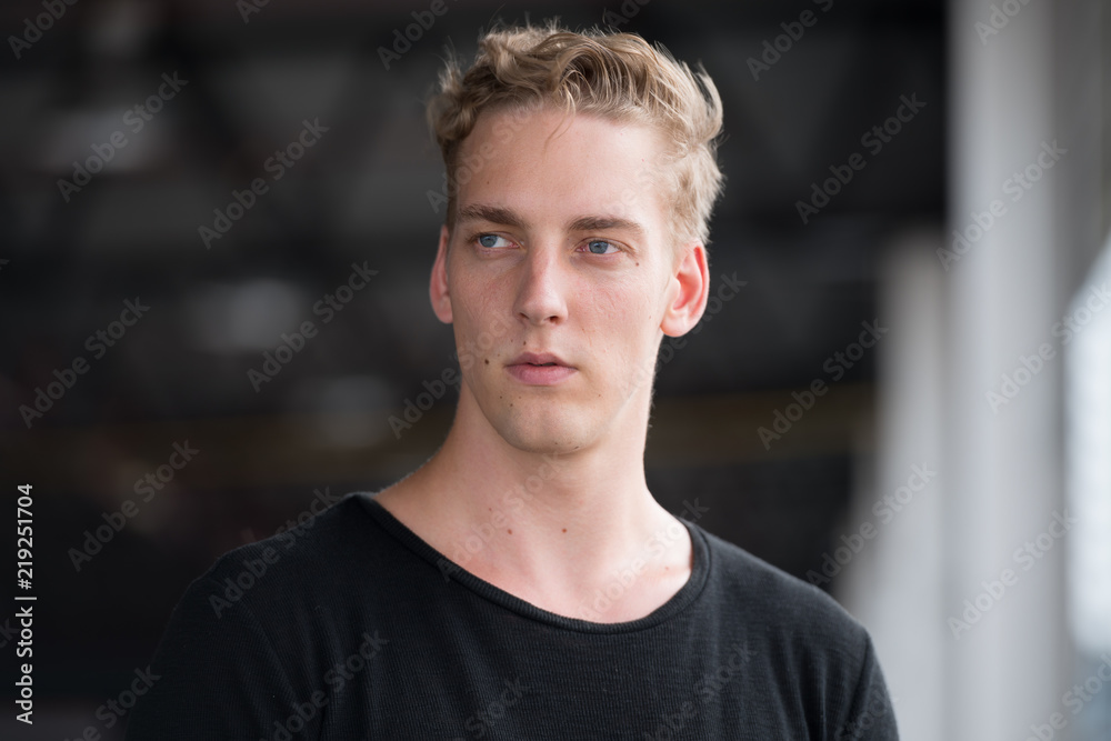 Young handsome man with curly hair thinking outdoors Young handsome man with curly hair thinking outdoors