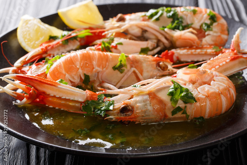 Foto Boiled Nephrops norvegicus, Norway lobster, Dublin Bay prawn, langoustine or scampi close-up with sauce and lemon