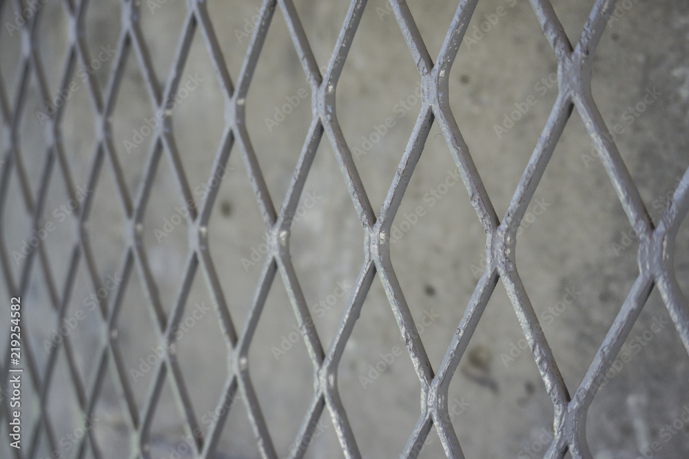 Naklejka premium Metal mesh on cement wall background