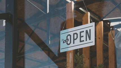 CU we are open sign hanging on the entrance door of a small cafe. Small business concept