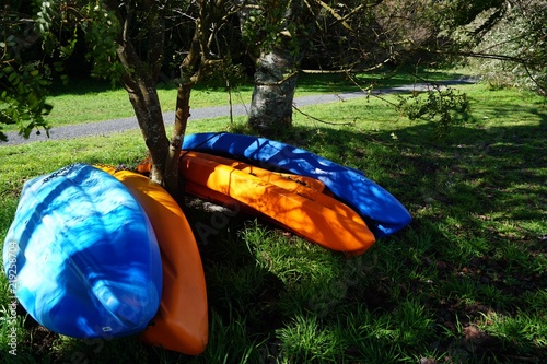 upturned colourful boats on grass