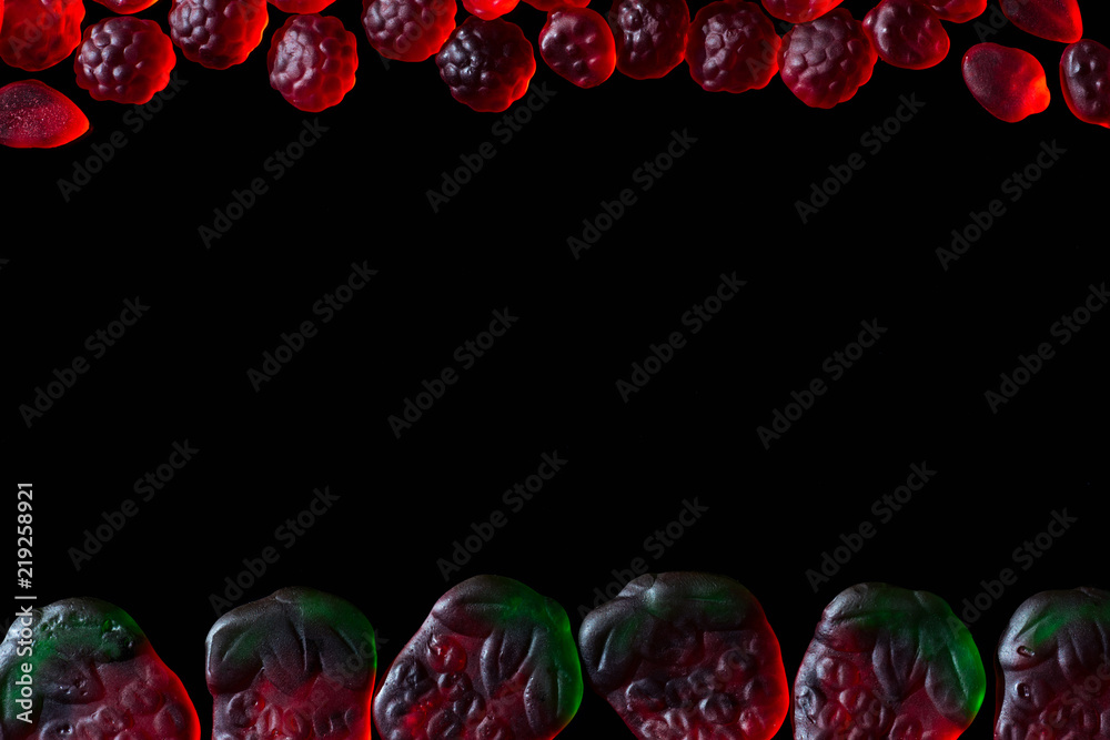 top view of jelly candies in shape of raspberries and strawberries isolated on black top view of jelly candies in shape of raspberries and strawberries isolated on black